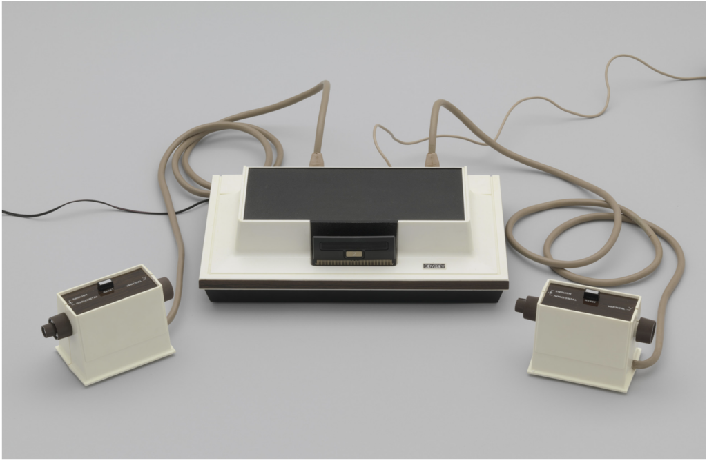 Original Magnavox Odyssey video game console with a white and brown rectangular body and wired controllers.
